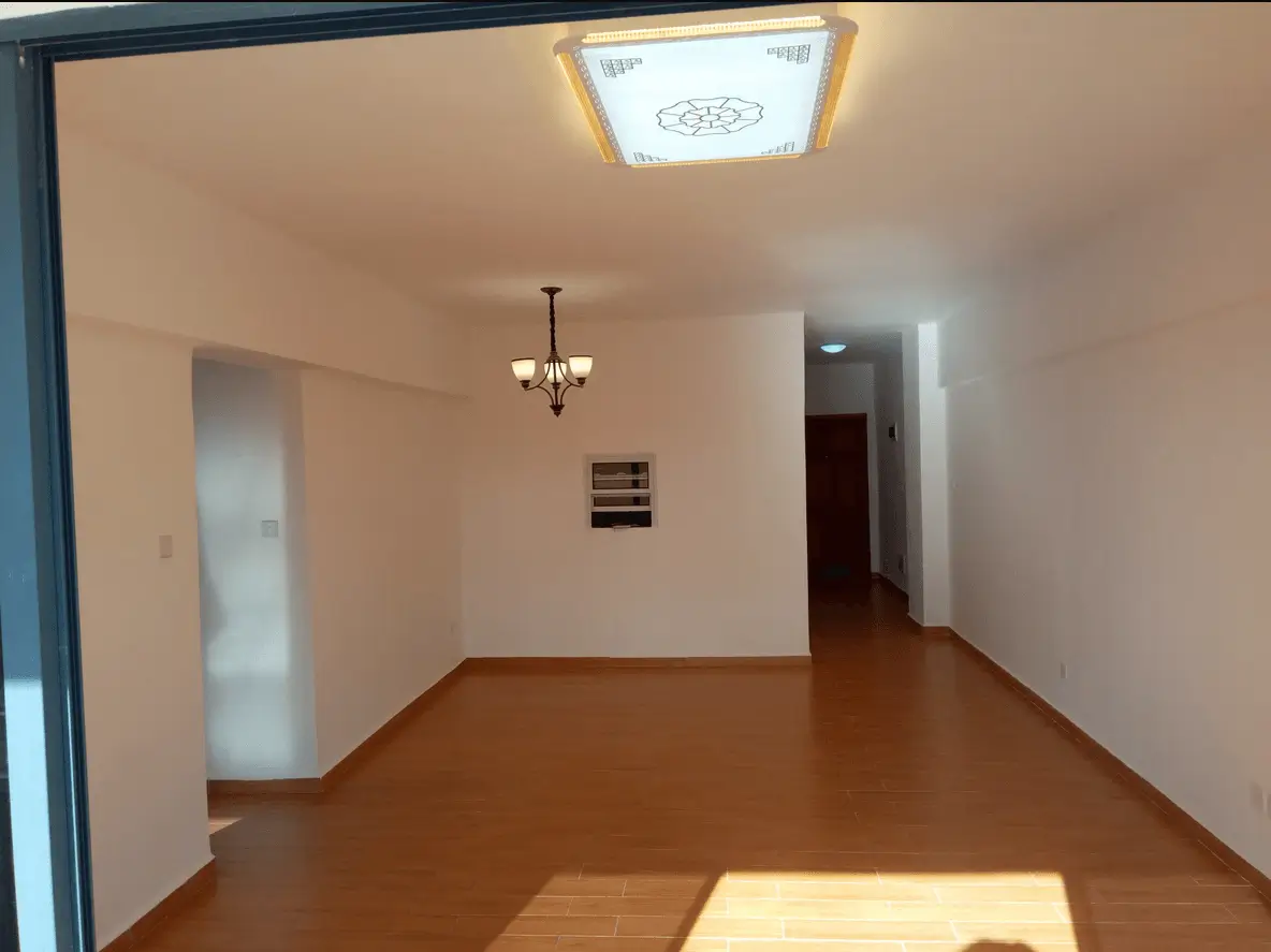 Spacious empty living room with wooden flooring and pendant lighting