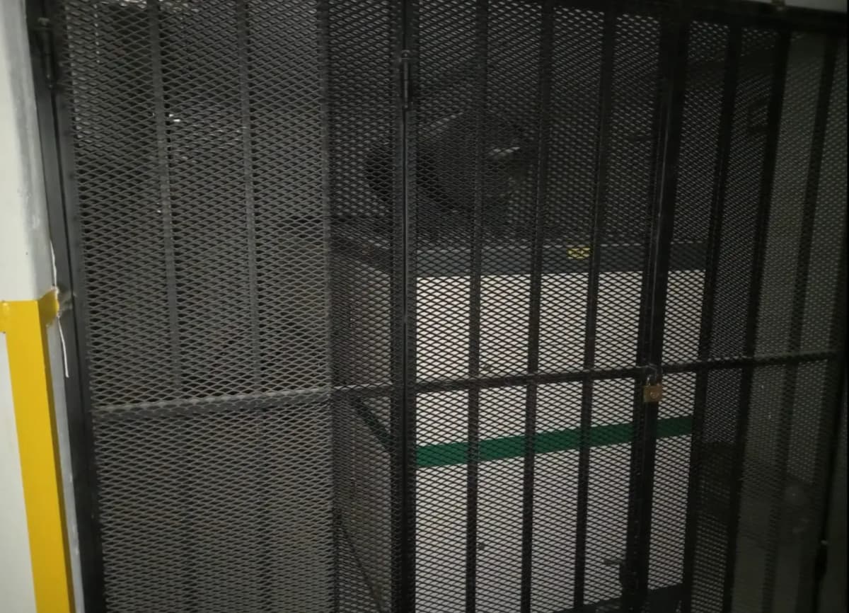 Secure parking garage with metal mesh gate enclosure