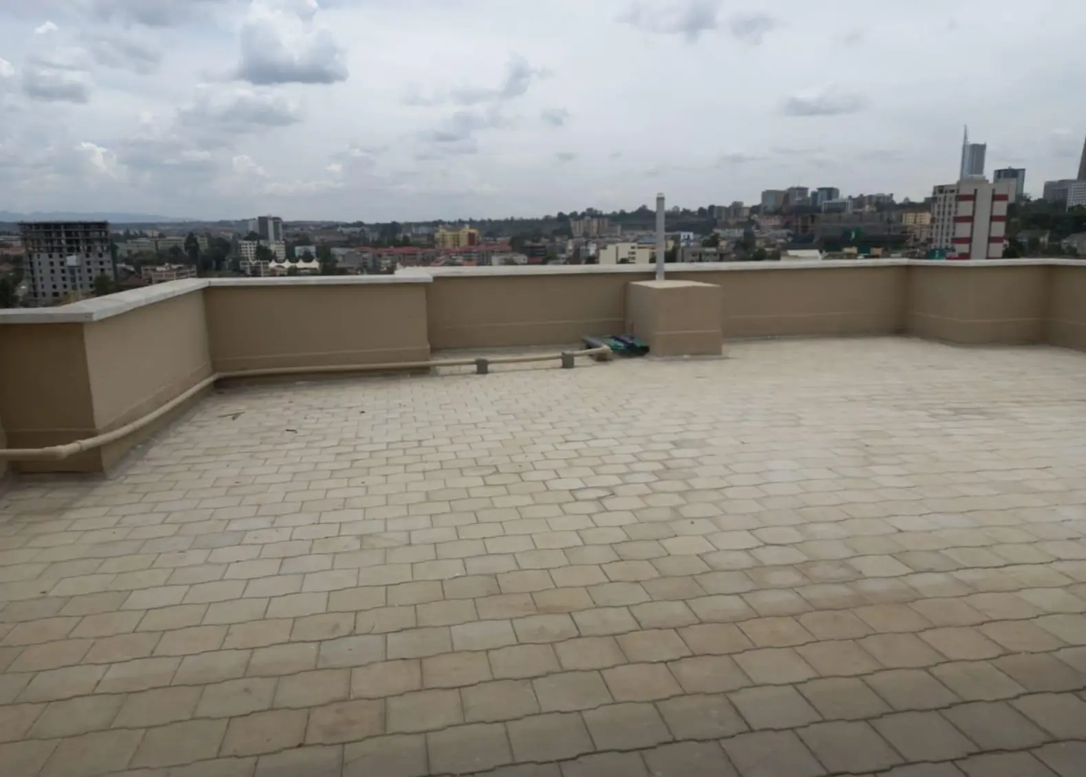 Spacious rooftop terrace with paved flooring and city views