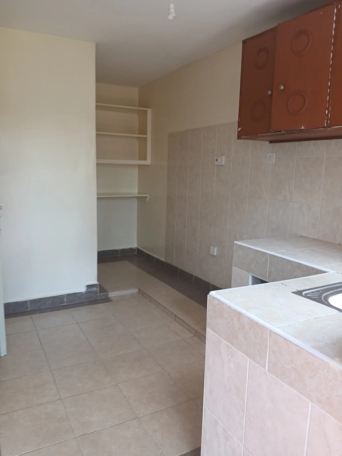 Spacious kitchen with cooking area and open shelving storage