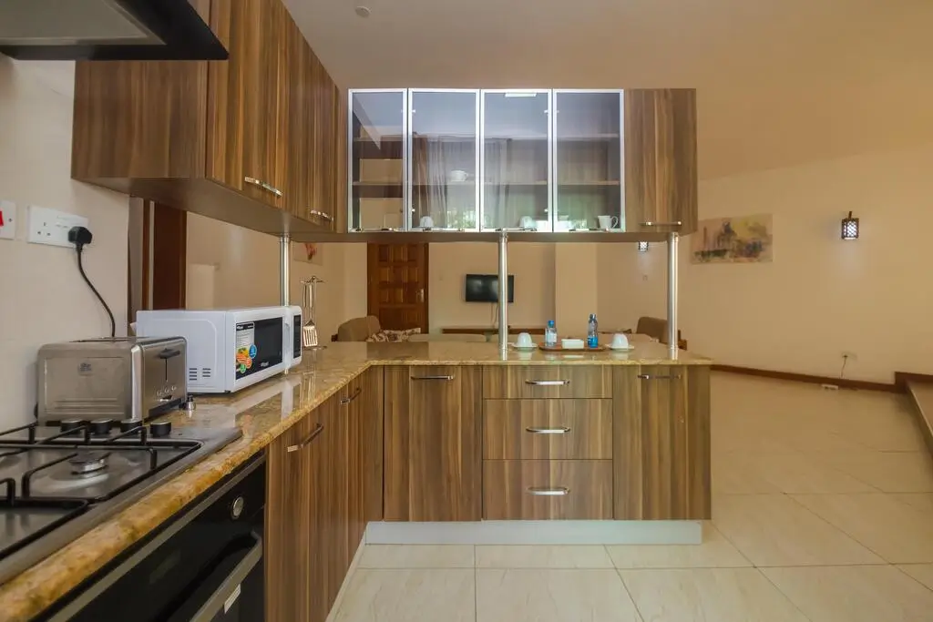 Open-plan kitchen with wood cabinetry and dining counter