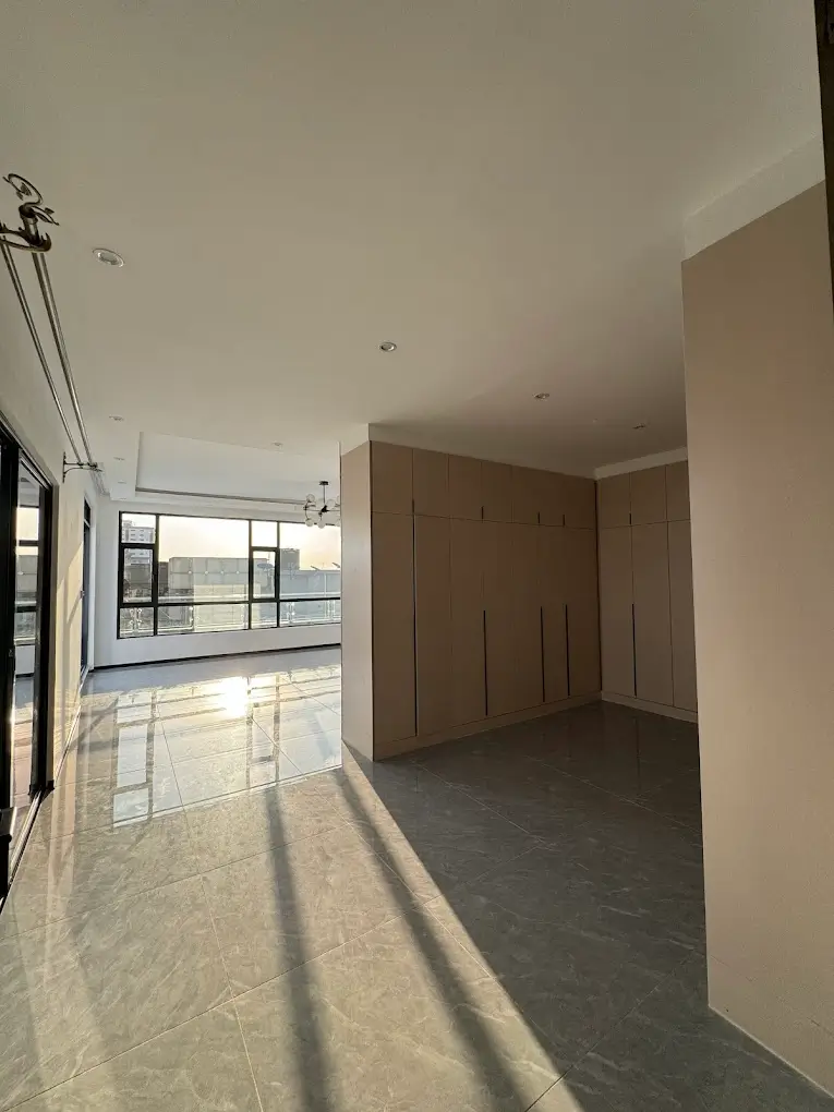 Spacious open-plan living area with natural light and windows
