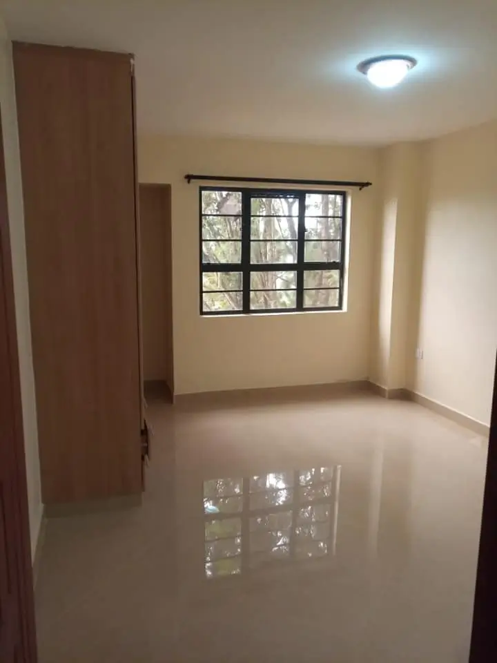 Spacious bedroom with barred window and polished concrete floor