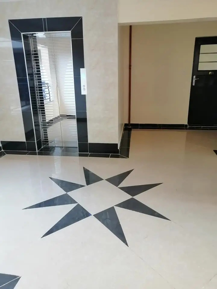 Modern lobby with geometric floor pattern and glass entrance