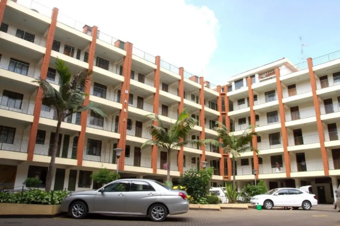 Modern multi-story apartment complex with red brick columns