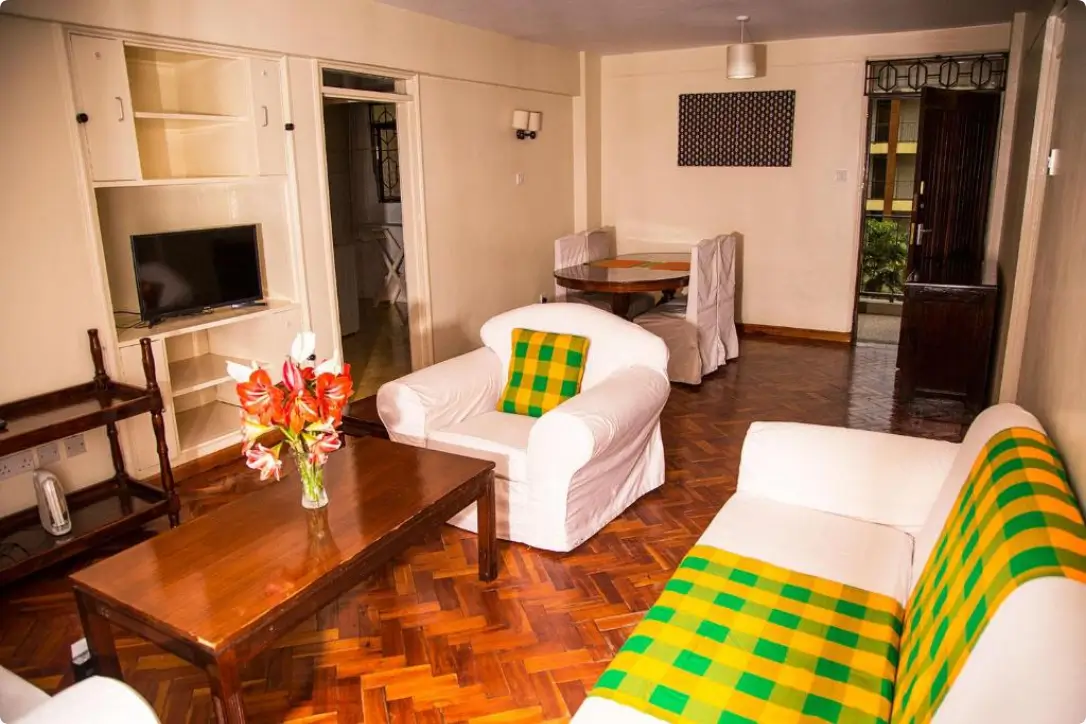 Spacious living room with wooden floors, sofa, and TV entertainment unit