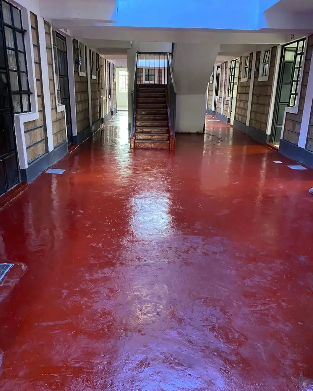 Spacious lobby with polished red floor and multiple doors