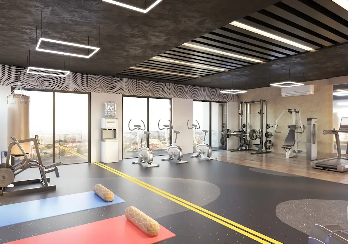 Modern gym with fitness equipment, mirrors, and floor mats