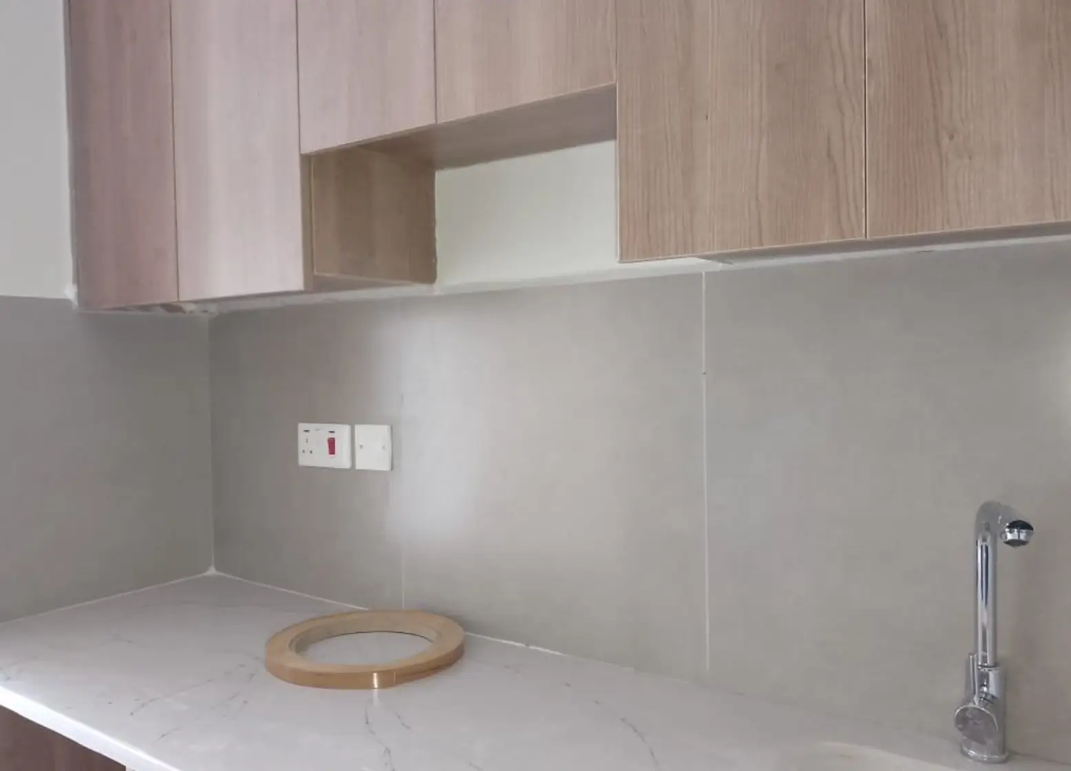 Modern kitchen with white countertop and wooden cabinetry