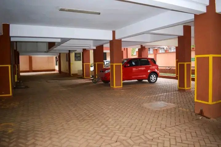 Underground parking garage with red vehicle and yellow safety pillars