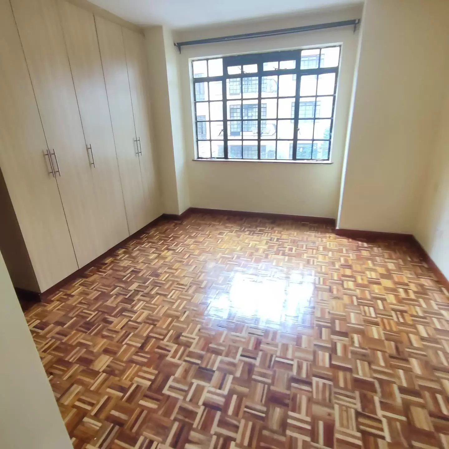 Bright bedroom with built-in wardrobes and parquet flooring