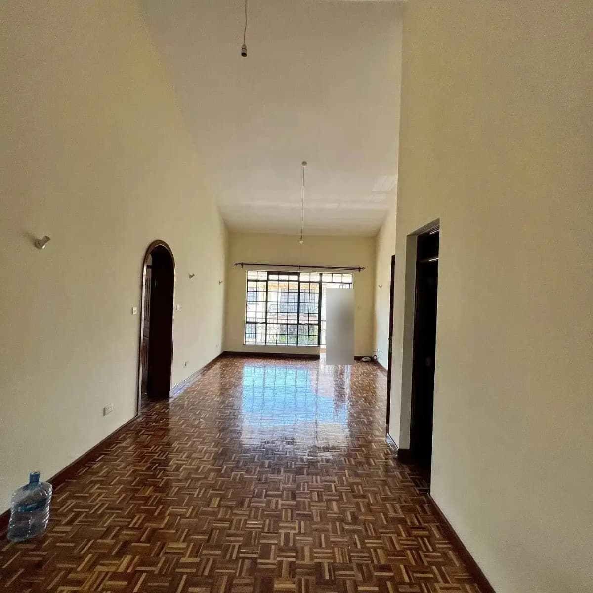 Bright corridor with herringbone flooring and barred window