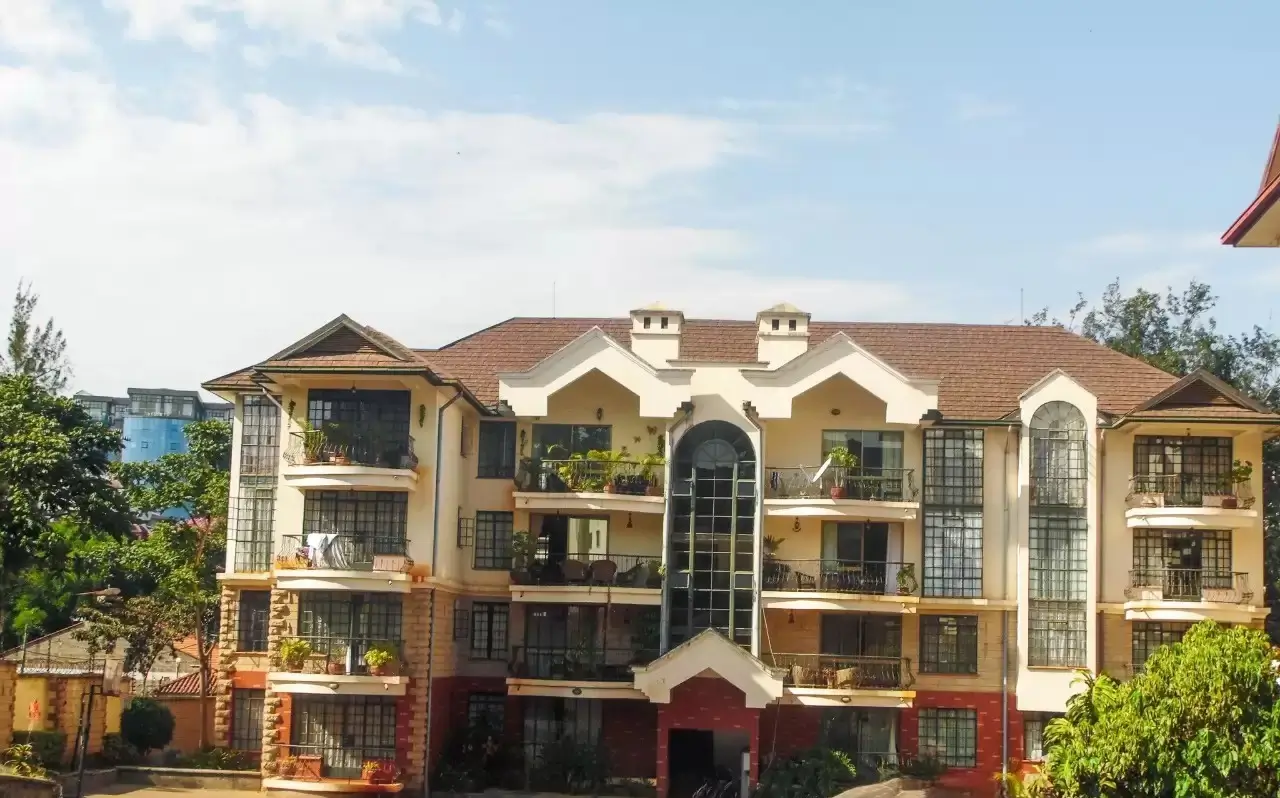 Multi-story residential building facade with cream and brick exterior