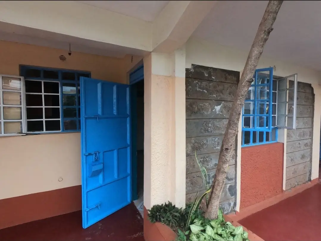 Building entrance with blue door and covered compound area