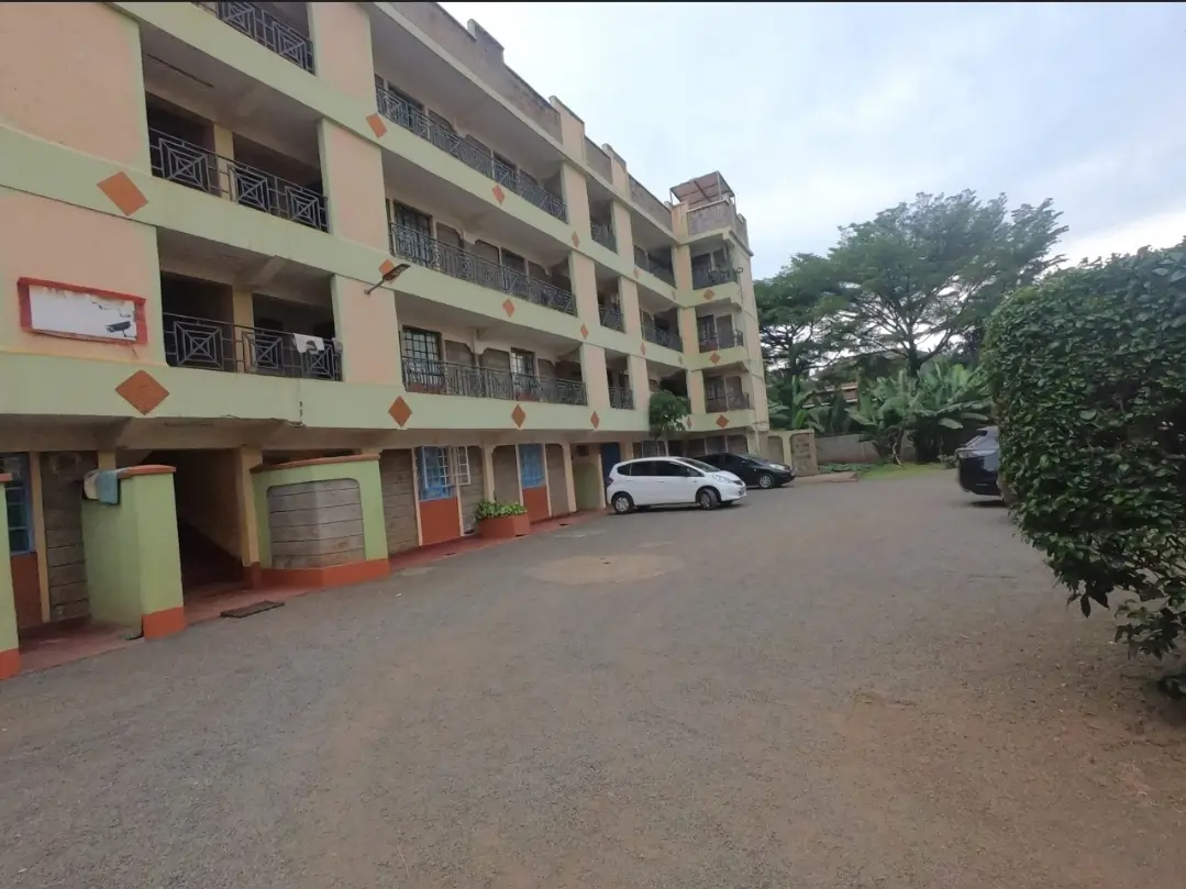 Multi-story apartment building with ground-level parking compound