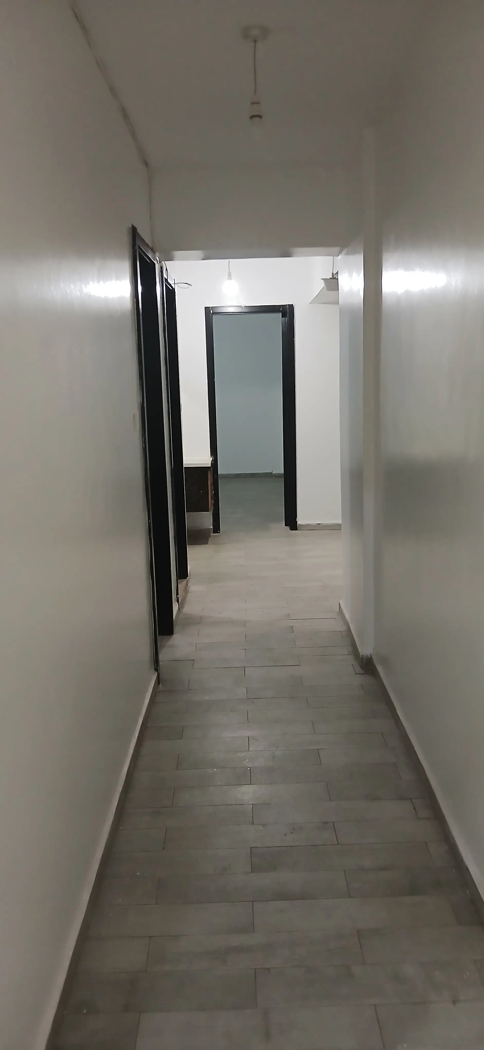 Clean corridor with tile flooring and white walls