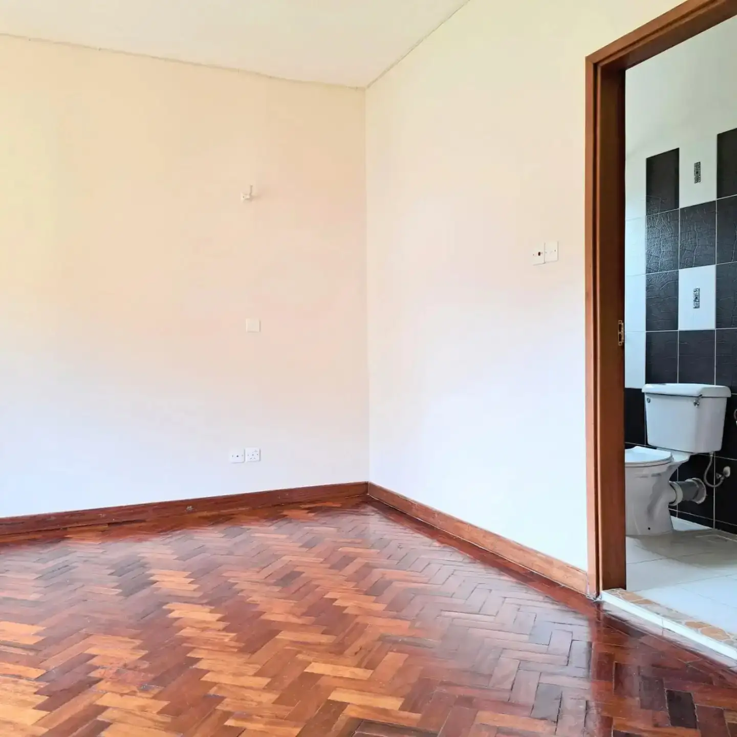 Spacious bedroom with parquet flooring and ensuite bathroom