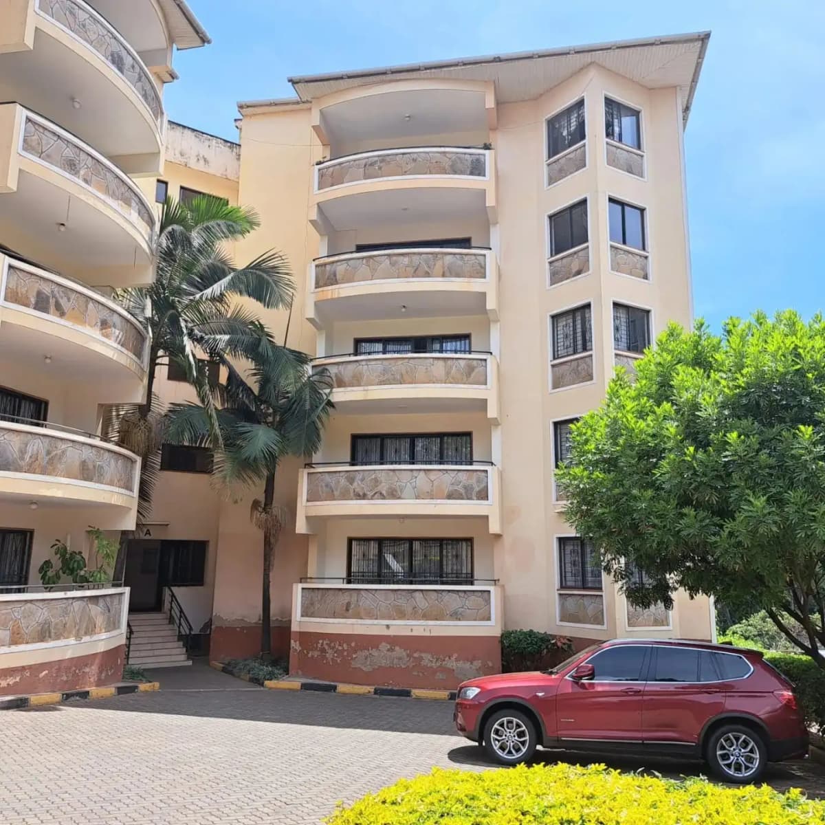 Multi-story residential building with curved balconies and parking