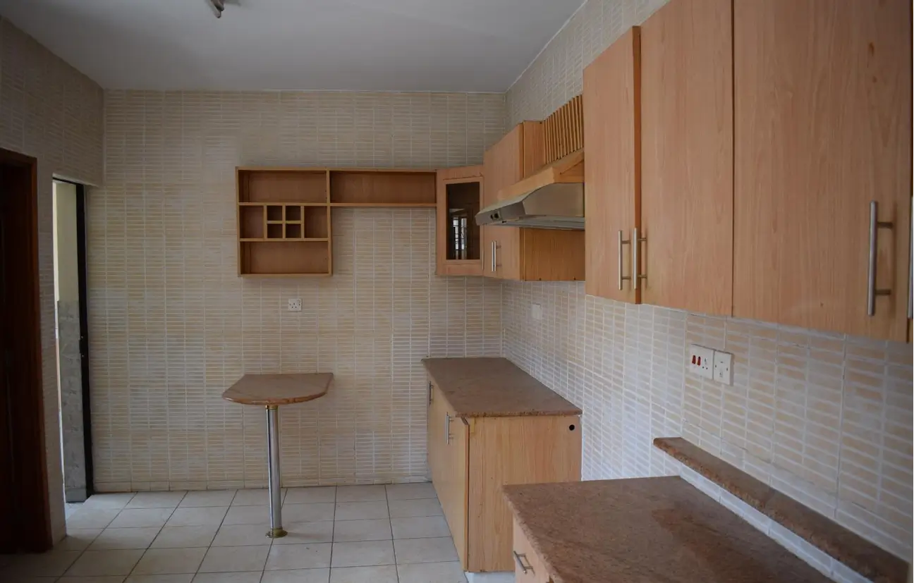 Open-plan kitchen with wooden cabinetry and breakfast bar seating