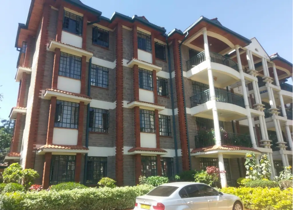 Modern multi-story brick apartment building with landscaped compound