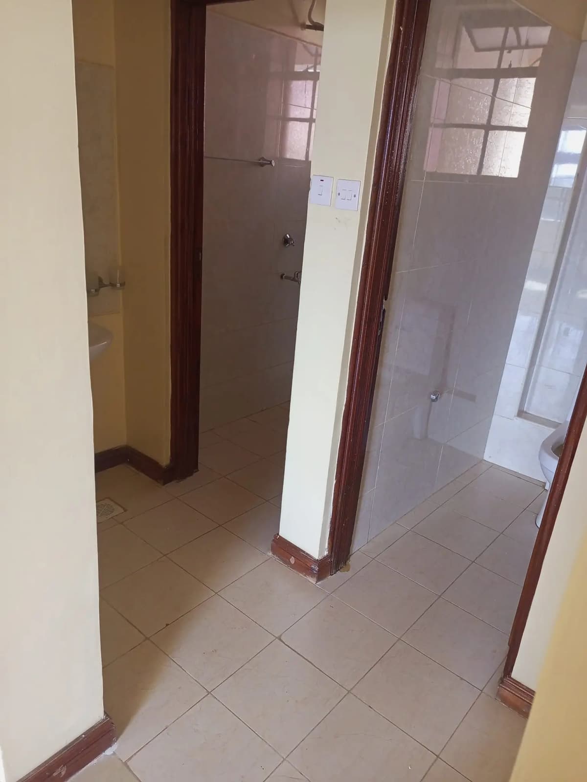 Tiled hallway with wooden door frames and pillars
