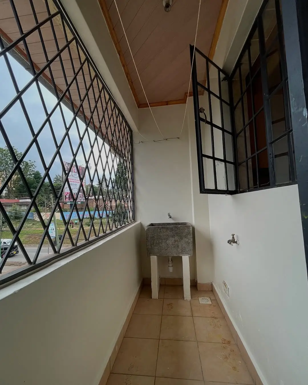 Narrow balcony with security grille and ceramic tile flooring