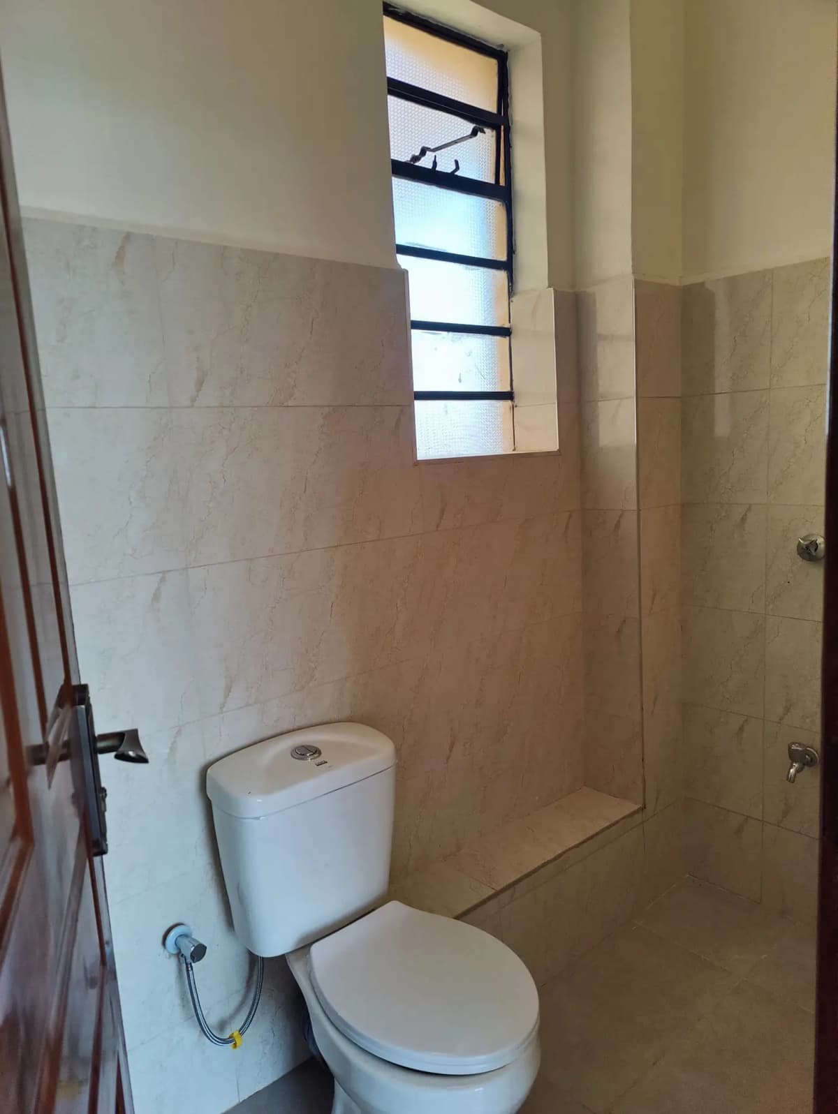 Simple bathroom with toilet, cistern, and high window