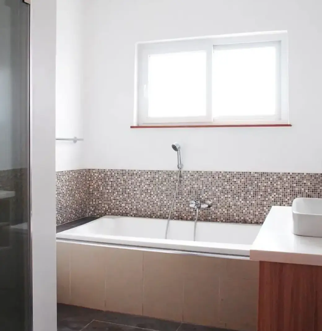 Modern bathroom with mosaic tile accent wall and soaking tub