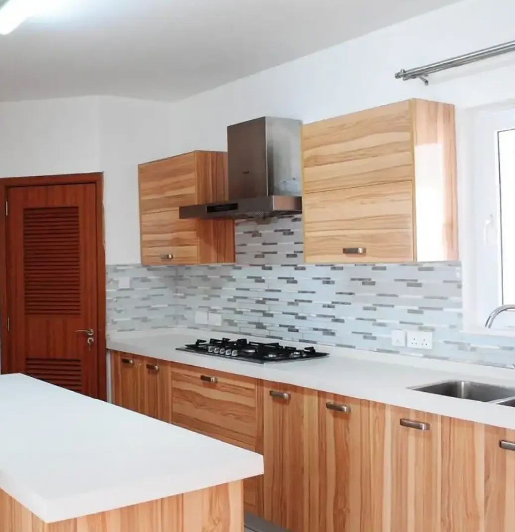 Modern kitchen with wood cabinets, gas cooktop, tile backsplash