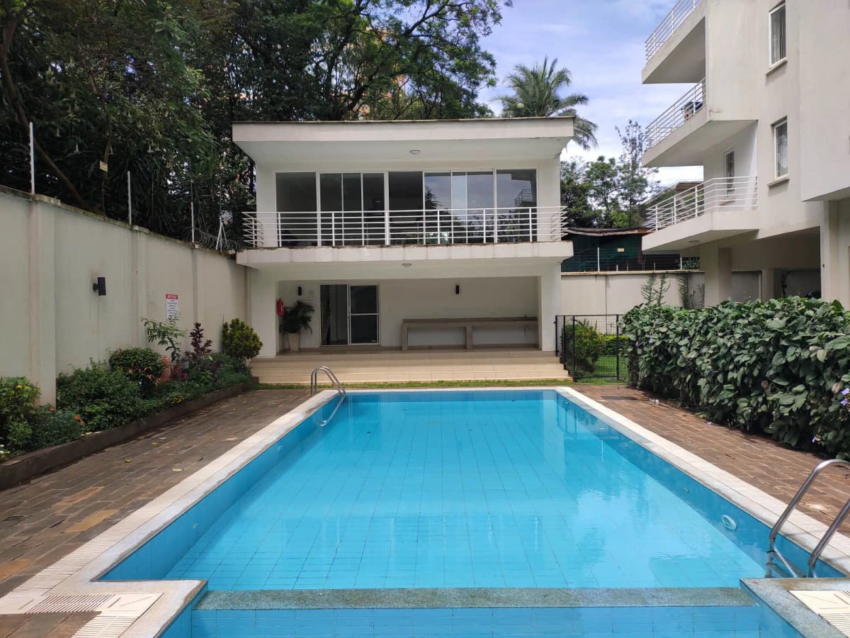 Rectangular swimming pool with brick deck and modern villa