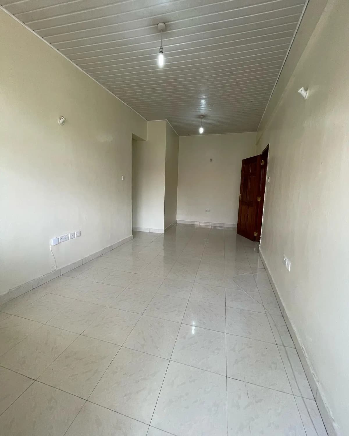 Empty corridor with tiled flooring and neutral walls