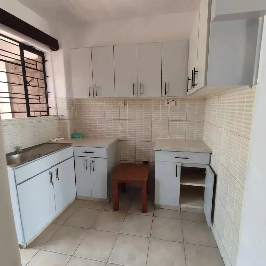 Compact kitchen with white cabinetry and cream tile backsplash
