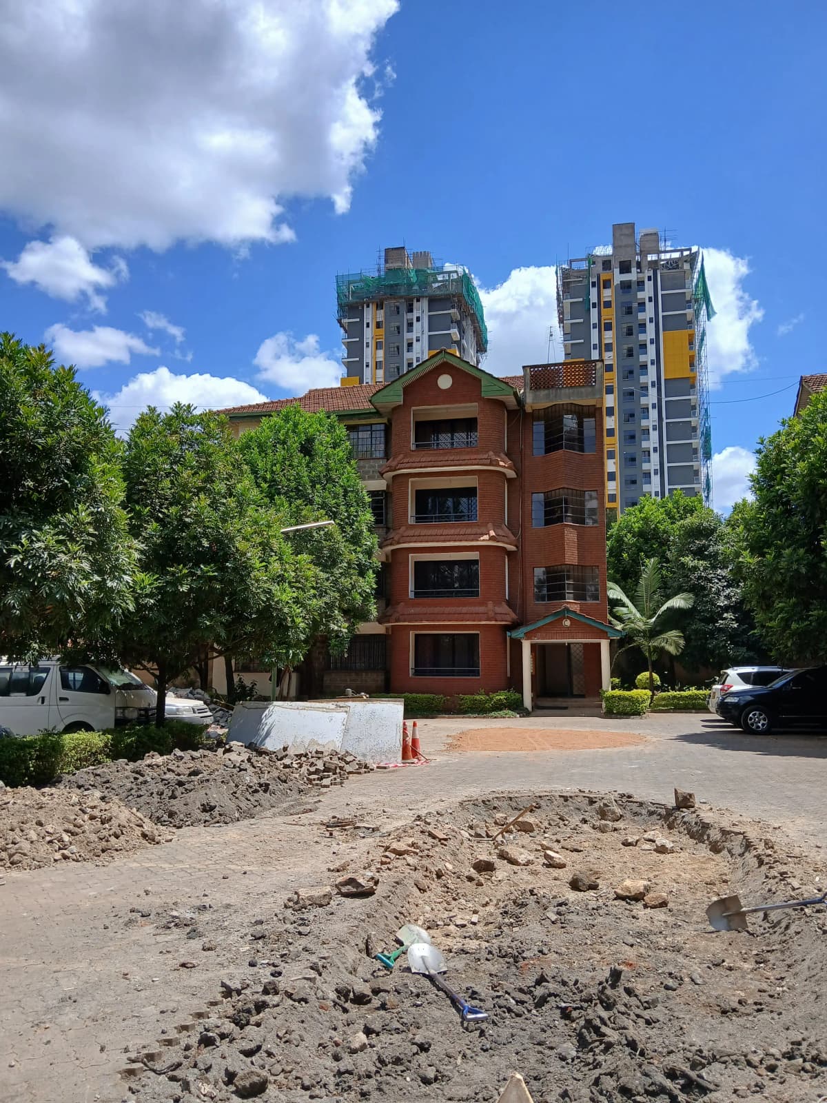 Red-brick residential building with compound entrance and grounds