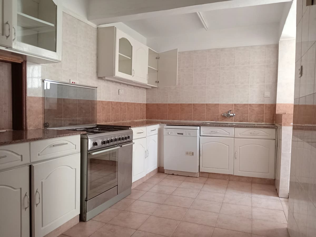 Spacious kitchen with cream cabinets, gas stove, terracotta tiles