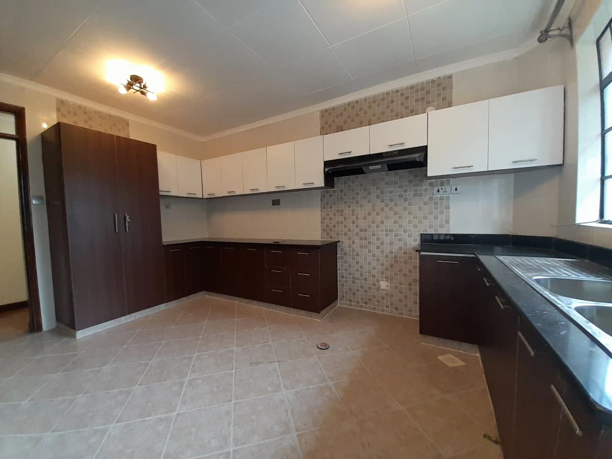 Spacious modern kitchen with white upper cabinets and dark lower units