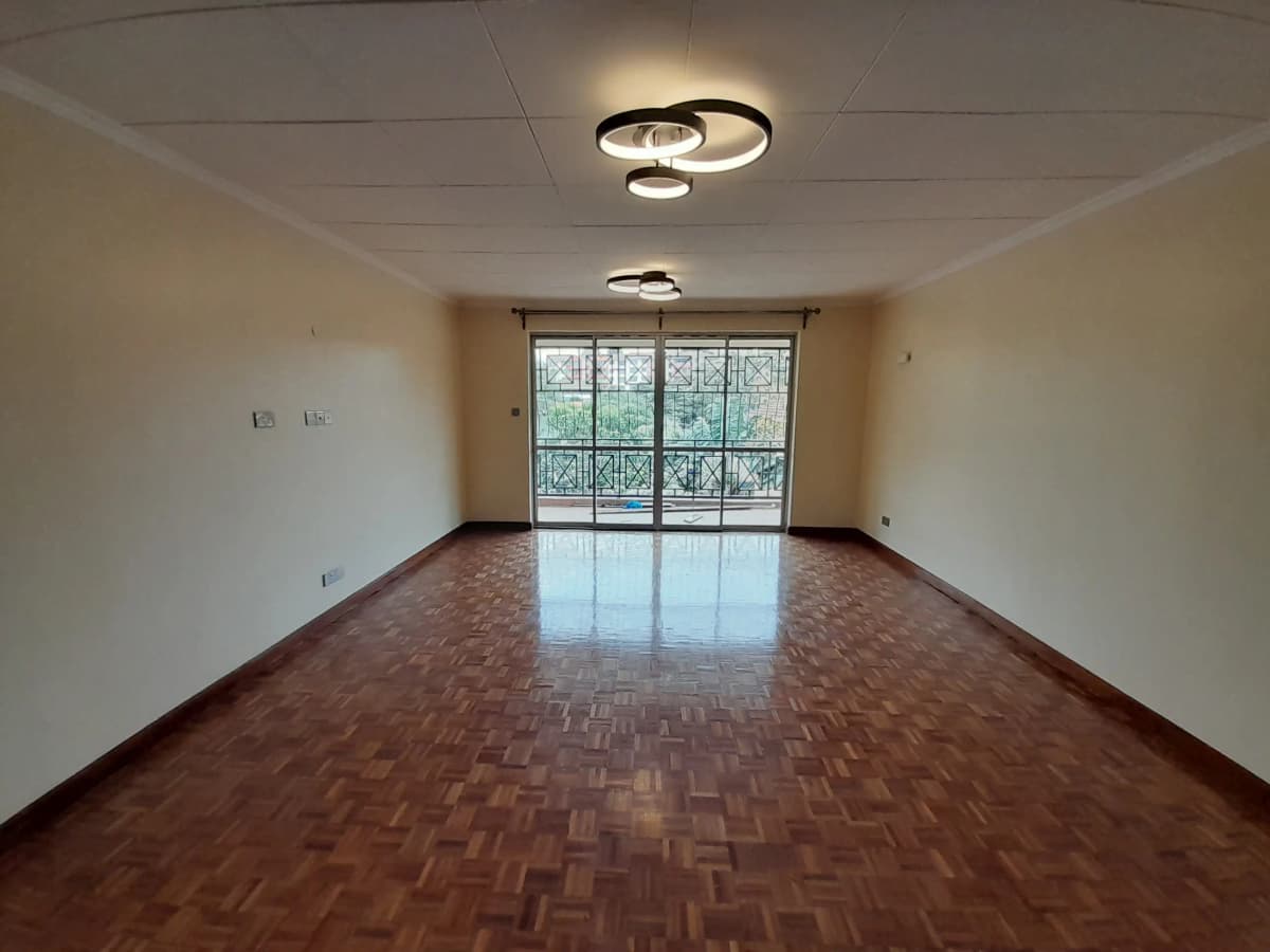 Spacious living room with herringbone wood flooring and balcony access