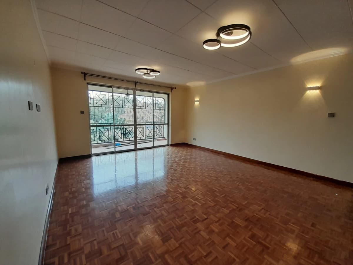 Spacious living room with herringbone flooring and balcony access