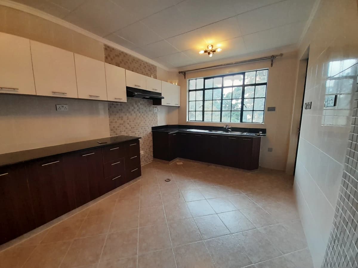 Spacious kitchen with two-tone cabinetry and large window