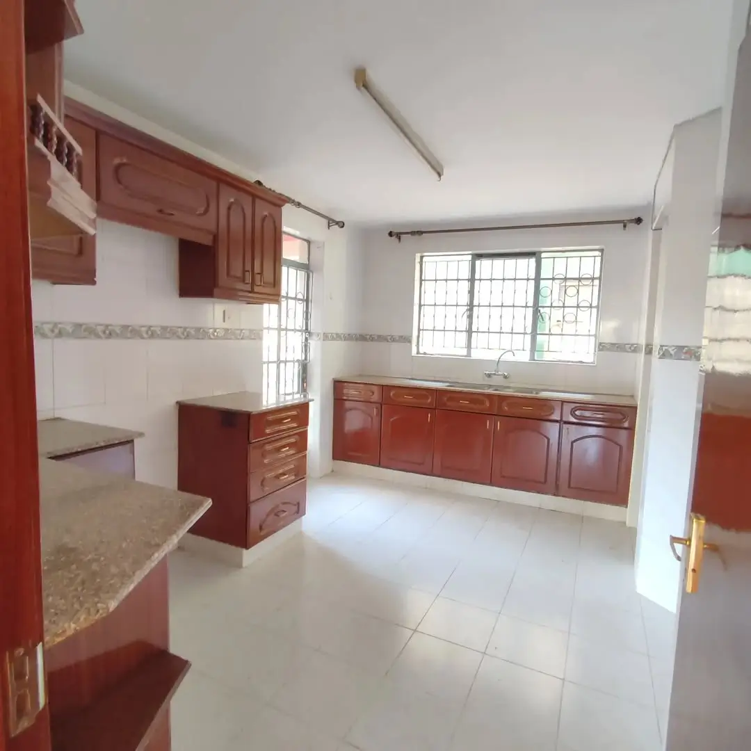 Spacious kitchen with red wooden cabinets and granite countertops