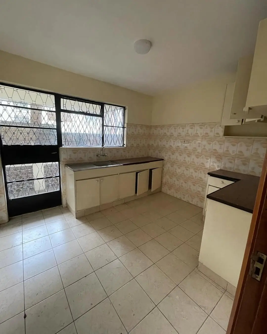 Spacious kitchen with cream cabinets and tiled flooring
