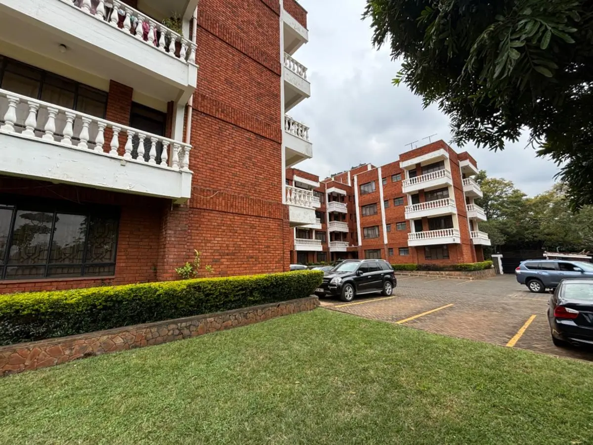 Multi-story brick apartment building with manicured compound grounds
