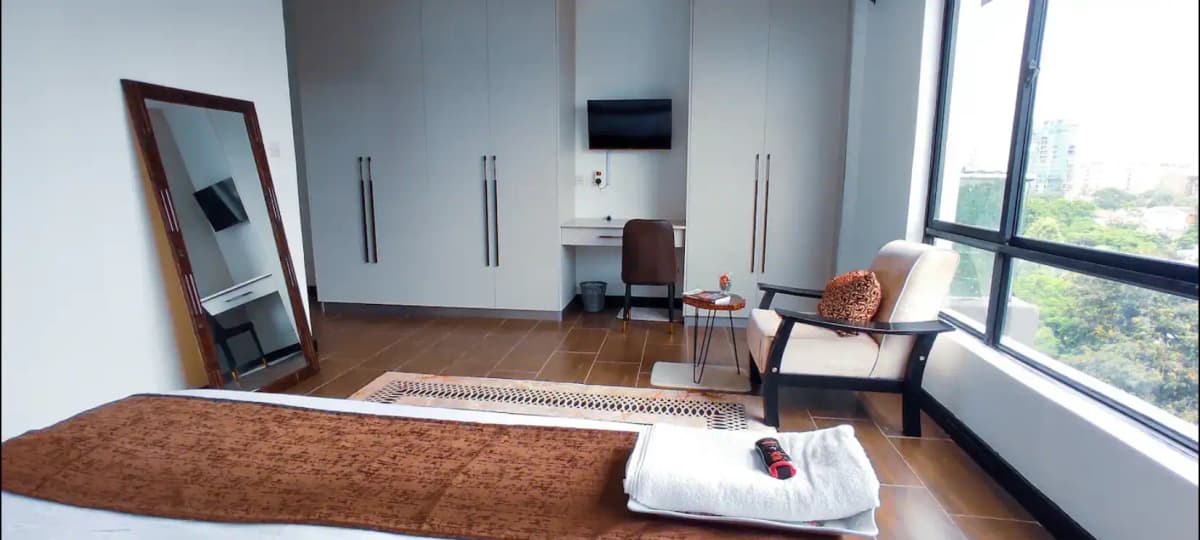 Modern bedroom with built-in wardrobes and city views