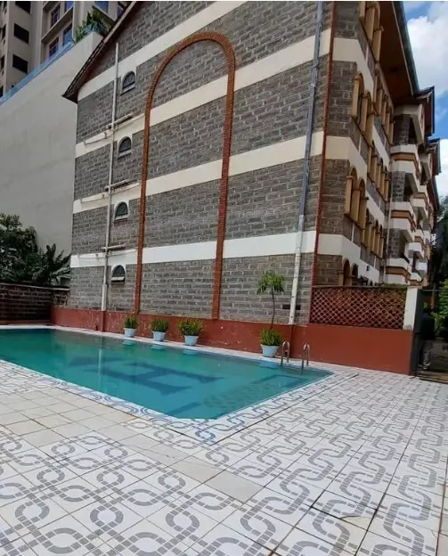 Residential swimming pool with patterned deck and building facade
