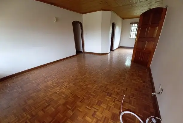 Spacious empty living room with herringbone wooden flooring