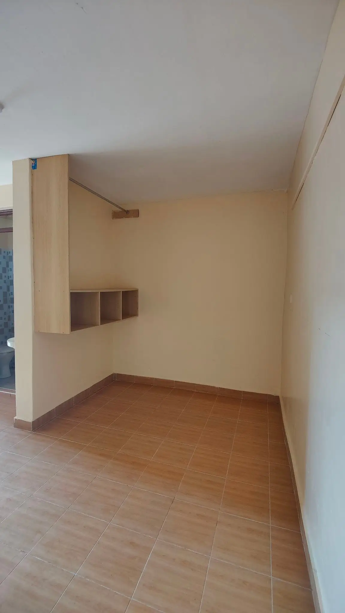 Empty bedroom with wooden flooring and built-in shelving