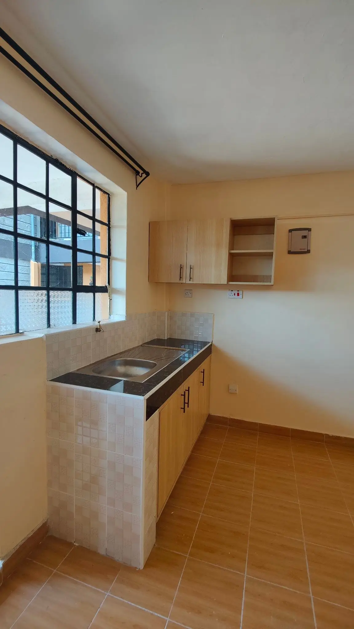 Compact kitchen with stove, sink, and wall-mounted cabinets