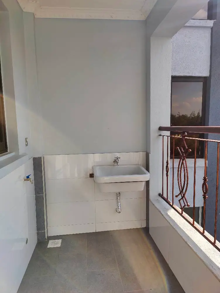 Balcony with utility sink and railing overlooking grounds