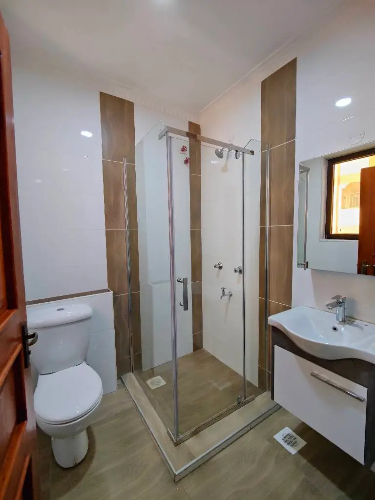 Modern bathroom with glass shower enclosure and white vanity