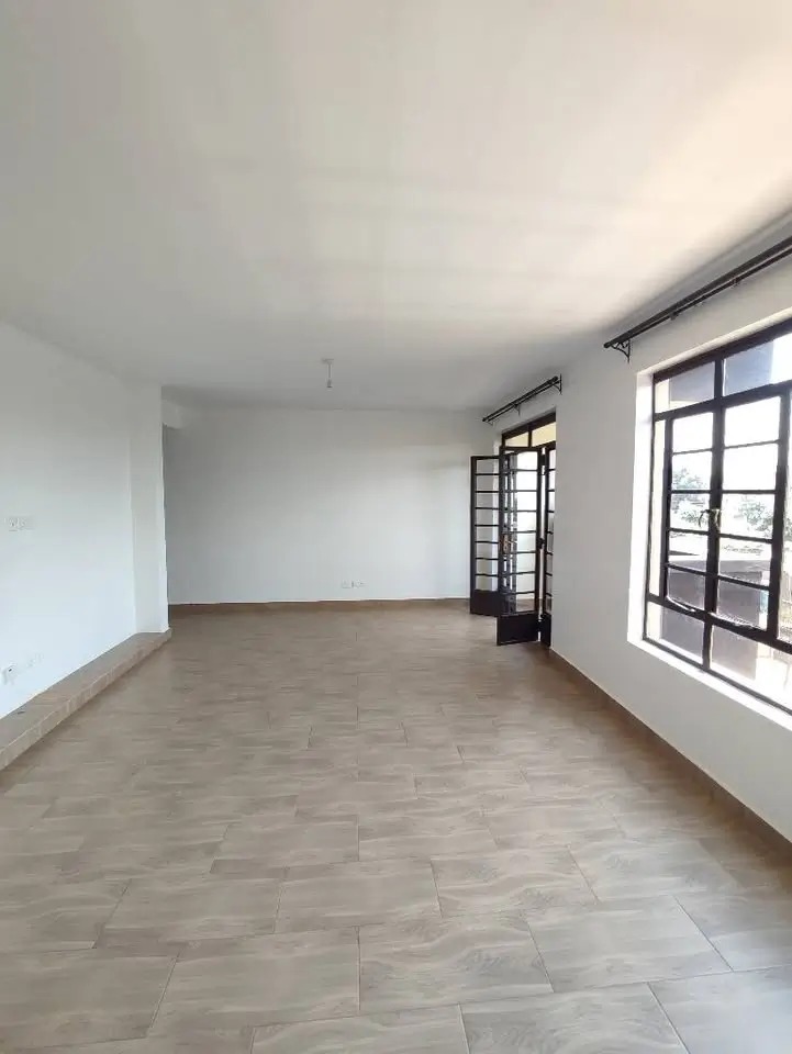 Spacious empty living room with large windows and tiled flooring