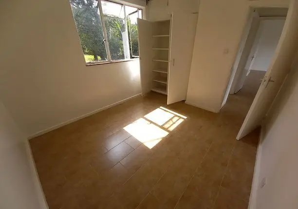 Spacious bedroom with natural light and built-in shelving